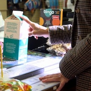 Un carton de deux litres de lait à la caisse d'un dépanneur.