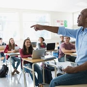 Un professeur d'une école secondaire montrant du doigt un élève dans sa classe