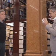 Deux hommes discutent dans la bibliothèque de l'Assemblée nationale. 