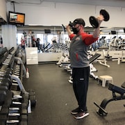 Un homme soulève des poids dans une salle d'entraînement.