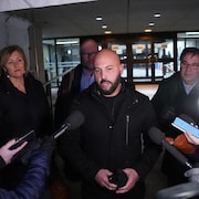 Éric Gingras, accompagné de Magali Picard, de Robert Comeau et de François Énault, s'adresse aux journalistes à l'extérieur d'un édifice.