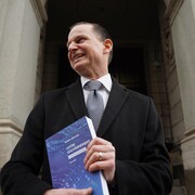 Le ministre Girard tenant une copie du budget 2022 du Québec.