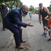 Le chef conservateur Erin O'Toole tente de serrer la main à un enfant.