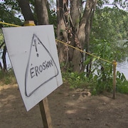 Une pancarte qui dit érosion avec un point d'exclamation sur le bord de la rivière Saint-Maurice.