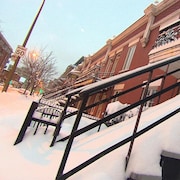 L'escalier d'un appartement de Montréal est couvert de neige.