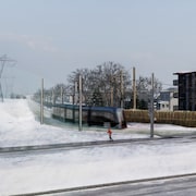 Illustration du tramway circulant l'hiver à la hauteur du chemin des Quatre-Bourgeois et du boulevard Pie-XII.