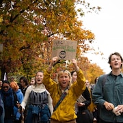 Une dizaine de manifestants, dont une brandit une pancarte, scandent des slogans sur le campus de l'Université de la Colombie-Britannique.