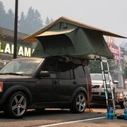 Une tente a été installée par-dessus une voiture, lors des évacuations causées par les feux de forêt.