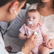 Un pédiatre examine un bébé.