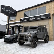 Deux v&eacute;hicules de luxe sont stationn&eacute;s devant un b&acirc;tisse dans laquelle se trouve un garage. Les enseignes Exclusiv automotiv ainsi que VM Pro et Groupe GLM sont sur la b&acirc;tisse.