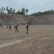 Des hommes prennent part à des exercices de tirs. 