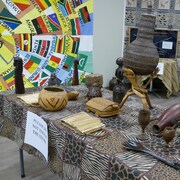 Des objets d'art traditionnel africain sont exposés sur des tables. 