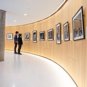 Deux personnes regardent une photo de l'exposition. 