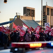 Des manifestants et des gyrophares de police.