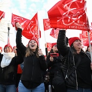 Des personnes manifestent avec des drapeaux de la Fédération autonome de l'enseignement.