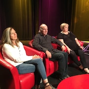 Trois personnes assises dans des fauteuils, sourient tristement en regardant une personne en face d'elle hors cadre. De gauche à droite : Annette, Paul et Suzanne Campagne.