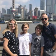 Une femme et un homme avec leurs deux enfants devant la ville de Shanghai.