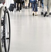 Une personne circule à fauteuil roulant parmi des gens qui n'en ont pas besoin pour se déplacer.