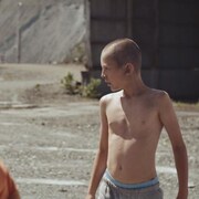 Deux jeunes garçons jouent dans une mine à ciel ouvert.
