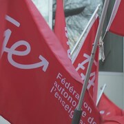 Des drapeaux rouges de la Fédération autonome de l'enseignement.