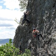 Une femme fait de la descente en rappel sur une falaise.