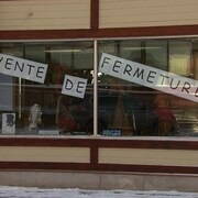 La vitrine de la boutique avec une affiche «Vente de fermeture ».
