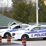 Deux auto-patrouilles du Service de police d'Ottawa bloquent une route.