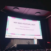 Une salle de cinéma où Marie Nelson annonce la sélection du festival Hot Docs 2024.