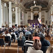 Des festivaliers qui écoutent une conférence.