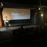 Le directeur de la programmation du Festival, Guillaume Whalen, s'adresse à une foule dans une salle de cinéma.