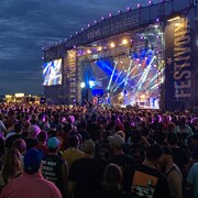 La grande scène du FestiVoix, de nombreux spectateurs, le sigle du FestiVoix surplombe la foule
