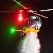 Un hélicoptère de nuit de la compagnieTalon relâche de l'eau lors d'un exercice d'entraînement.
