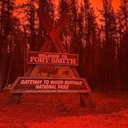 Le panneau d'entrée dans la ville de Fort Smith, dans un ciel rouge et enfumé par les feux. 