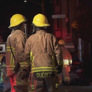 Des pompiers de Québec dans une rue du quartier Saint-Saiveur la nuit.