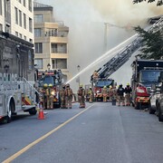 Des pompiers arrosent un immeuble.