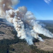 Vue aérienne d'un grand incendie qui brûle sur un territoire forestier, avec de grands panaches de fumée qui montent vers le ciel, le 20 avril 2024.