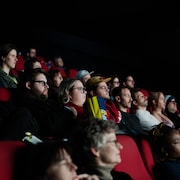 Des gens sont assis dans une salle de cinéma. 