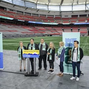 Le maire de Vancouver Ken Sim et des membres du gouvernement de la Colombie-Britannique dans le stade BC Place devant un podium, le 30 avril 2024.