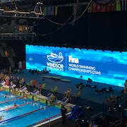 Un grand tableau d'affichage bleu devant une piscine à Windsor qui accueille les 13e Championnats de monde de natation en petit bassin FINA.