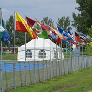 Les drapeaux des différentes délégations flottent au vent, au Complexe sportif Guillaume-Leblanc à Rimouski.