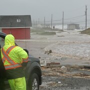 Un homme regarde un chemin inondé.