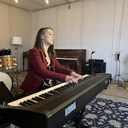 Une personne joue du piano dans un studio.