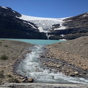 Un ruisseau se forme devant le lac qui se trouve sous un glacier des Rocheuses canadiennes.