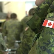 Écurson à l'effigie du drapeau canadienne sur le bras d'un uniforme de l'armée.