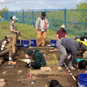 Des chercheurs s'affairent à creuser et fouiller le sol à la recherche d'artefacts.