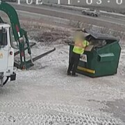 Un conducteur du camion de déchets qui se penche dans une benne.