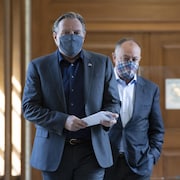Le premier ministre Francois Legault est accompagné du ministre de la Santé Christian Dubé. Tous deux portent un masque.