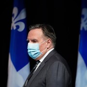 François Legault, de profil, porte un masque.