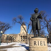 La statue de Louis Riel en avant-plan, la devanture de l'Assemblée législative du Manitoba en arrière-plan.