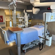 Un lit d'hôpital entouré d'appareils médicaux.